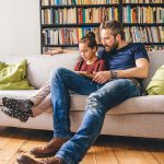 Father and daughter using a tablet at home.